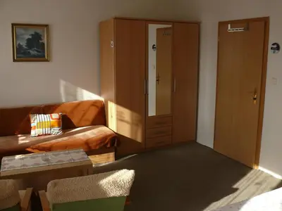a living room with a couch and a cabinet at Penzion Dana Troja in Prague