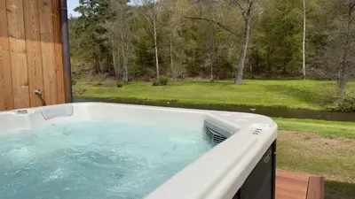 a hot tub on a deck with a view of a yard at River wellness in Jince