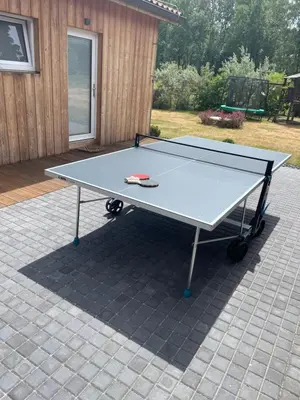 a ping pong table sitting on a patio at River wellness in Jince