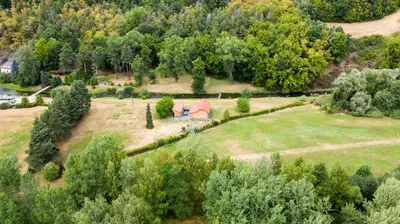an aerial view of a farm with a house in a field at River wellness in Jince