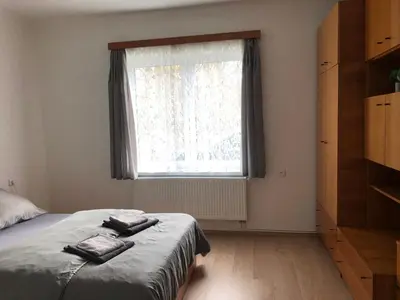 a bedroom with a bed and a large window at Apartmány Jevany in Jevany