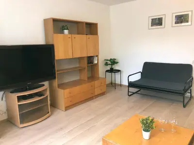 a living room with a flat screen tv and a couch at Apartmány Jevany in Jevany