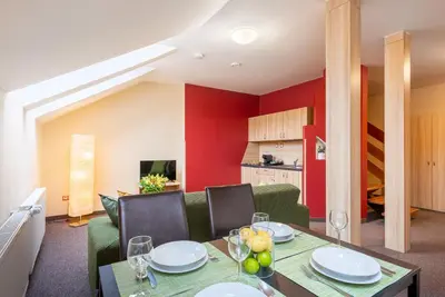 a dining room with a table and chairs and a red wall at Hotel Libero in Prague
