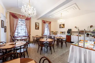 a dining room with tables and chairs and chandeliers at Hotel Libero in Prague