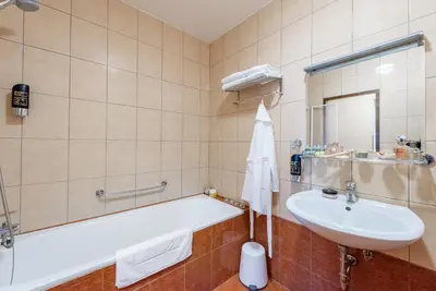 a bathroom with a bath tub and a sink at Hotel Libero in Prague