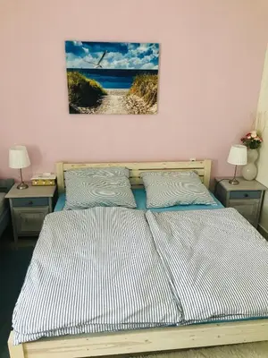 a bedroom with a bed with two tables and a painting on the wall at Apartmán U ŘEKY in Srbsko
