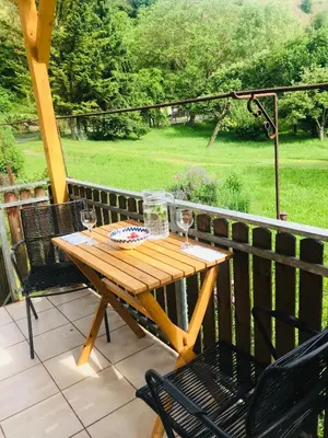 a wooden table and chairs on a deck with a view at Apartmán U ŘEKY in Srbsko