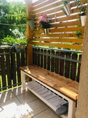 a wooden bench on a balcony with a fence at Apartmán U ŘEKY in Srbsko