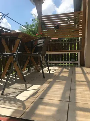 a wooden bench sitting on top of a patio at Apartmán U ŘEKY in Srbsko