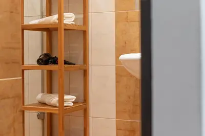 a bathroom with a shelf with towels and a sink at The BEST LOCATION in Prague, Charles Bridge & Old Town Square in Prague