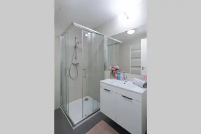 a white bathroom with a shower and a sink at Bright studio, 10min to the Centre, free Parking in Prague