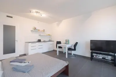 a living room with a bed and a tv and a table at Bright studio, 10min to the Centre, free Parking in Prague