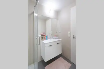 a white bathroom with a sink and a shower at Bright studio, 10min to the Centre, free Parking in Prague