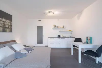 a living room with a couch and a table and a kitchen at Bright studio, 10min to the Centre, free Parking in Prague