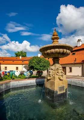a large building with an orange roof with a fountain at Zámecký hotel & Wellness in Poděbrady