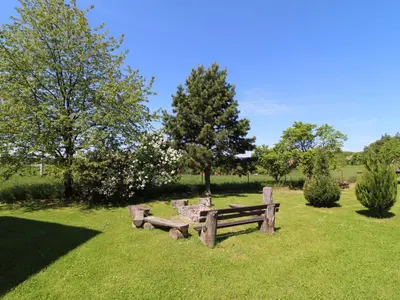 a park with two wooden benches in the grass at Apartment Rabyně-2 by Interhome in Rabyně