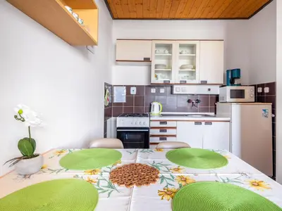 a kitchen with a table with chairs and a refrigerator at Apartment Rabyně-2 by Interhome in Rabyně