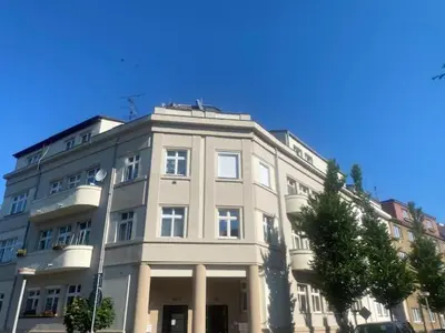a large white building with a tree in front of it at Walter&Sons Apartment Centro in Poděbrady