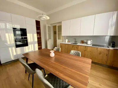 a kitchen with a wooden table and some chairs at Dobré časy Apartment in Poděbrady