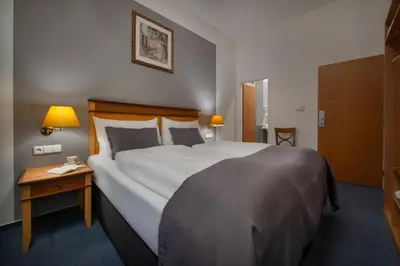 a hotel room with a large bed and a table at Prague Season Hotel in Prague