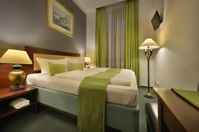 a hotel room with a large bed with green curtains at Prague Season Hotel in Prague