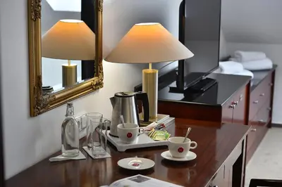 a table with two cups and a lamp and a mirror at Prague Season Hotel in Prague