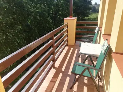 a deck with two chairs and a table on it at Slapská přehrada Radíč in Sedlčany