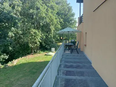 a balcony with a table and an umbrella at Slapská přehrada Radíč in Sedlčany