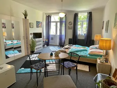 a room with a bed and a table and chairs at Penzion Villa Amélie in Mladá Boleslav