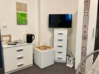 a room with a dresser with a tv on top at Penzion Villa Amélie in Mladá Boleslav