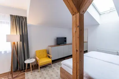a bedroom with a bed and a yellow chair at Hotel Restovna in Jíloviště