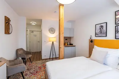 a bedroom with a white bed and a kitchen at Hotel Restovna in Jíloviště