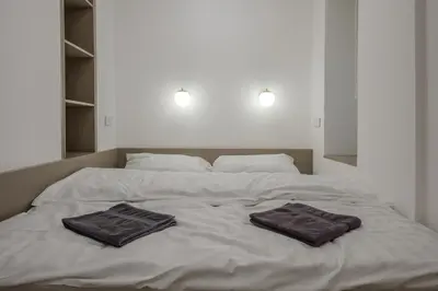 a white bed with two towels on top of it at Apartmán v srdci Prahy in Prague