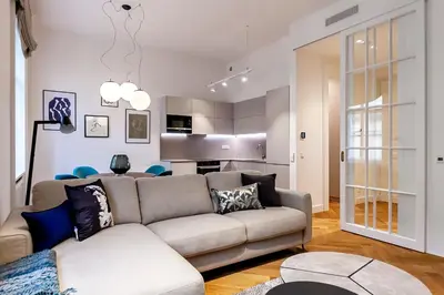 a living room with a couch and a kitchen at Luxury apartments in the city centre in Prague
