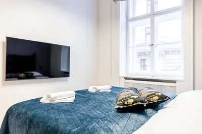 a bedroom with a bed with two pillows and a tv at Luxury apartments in the city centre in Prague