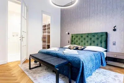 a bedroom with a bed with a green headboard at Luxury apartments in the city centre in Prague