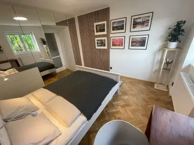 a bedroom with a bed and a desk and a mirror at Apartmán U Kolonády, Poděbrady in Poděbrady