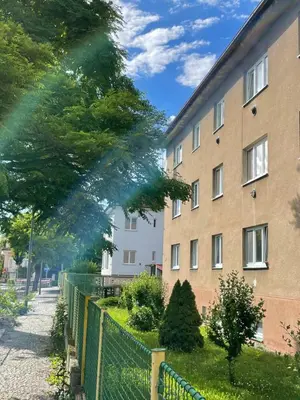 a building with a fence in front of a yard at Apartmán U Kolonády, Poděbrady in Poděbrady
