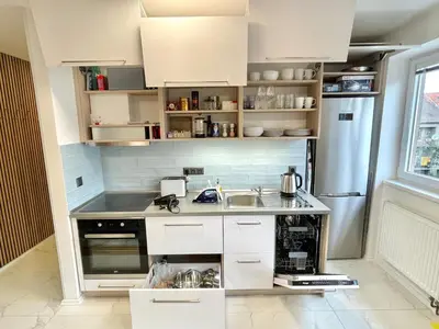 a kitchen with white cabinets and a sink at Apartmán U Kolonády, Poděbrady in Poděbrady