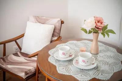 a table with two cups and a vase with flowers at Apartmán v Ladově kraji in Ondřejov