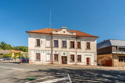 an old white building on the corner of a street at Apartmán v Ladově kraji in Ondřejov