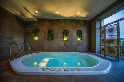 a bathroom with a large tub in a room at Hotel Berounka in Hřebečníky