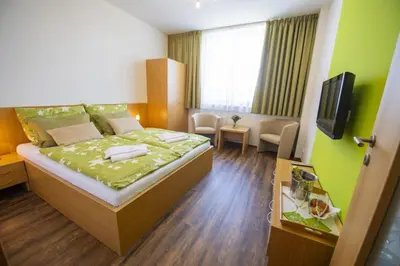 a hotel room with a bed and a living room at Hotel Berounka in Hřebečníky