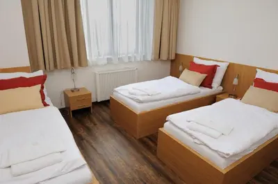 a room with two beds and two night stands at Hotel Berounka in Hřebečníky