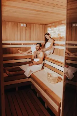 a man and a woman sitting in a sauna at Hotel Central Park in Poděbrady