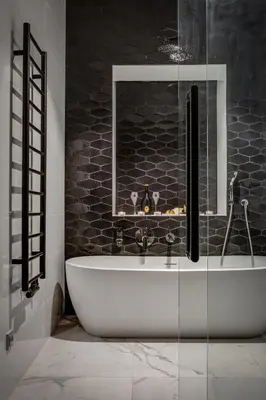 a bath tub in a bathroom with a black wall at Hotel Central Park in Poděbrady