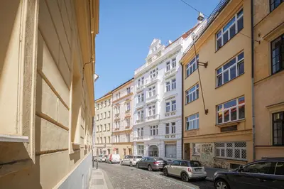 a city street with parked cars and buildings at Bright downtown studio in Prague