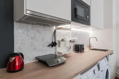 a kitchen counter with a sink and a microwave at Bright downtown studio in Prague