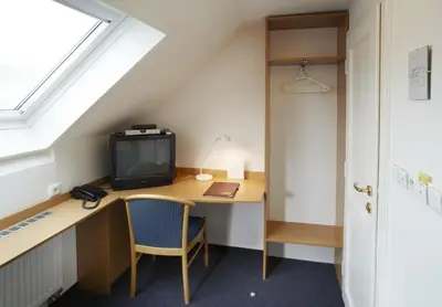 a room with a desk with a tv and a computer at Pension Kern in Prague