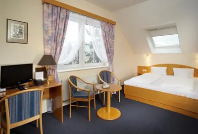 a hotel room with a bed and a desk with a computer at Pension Kern in Prague